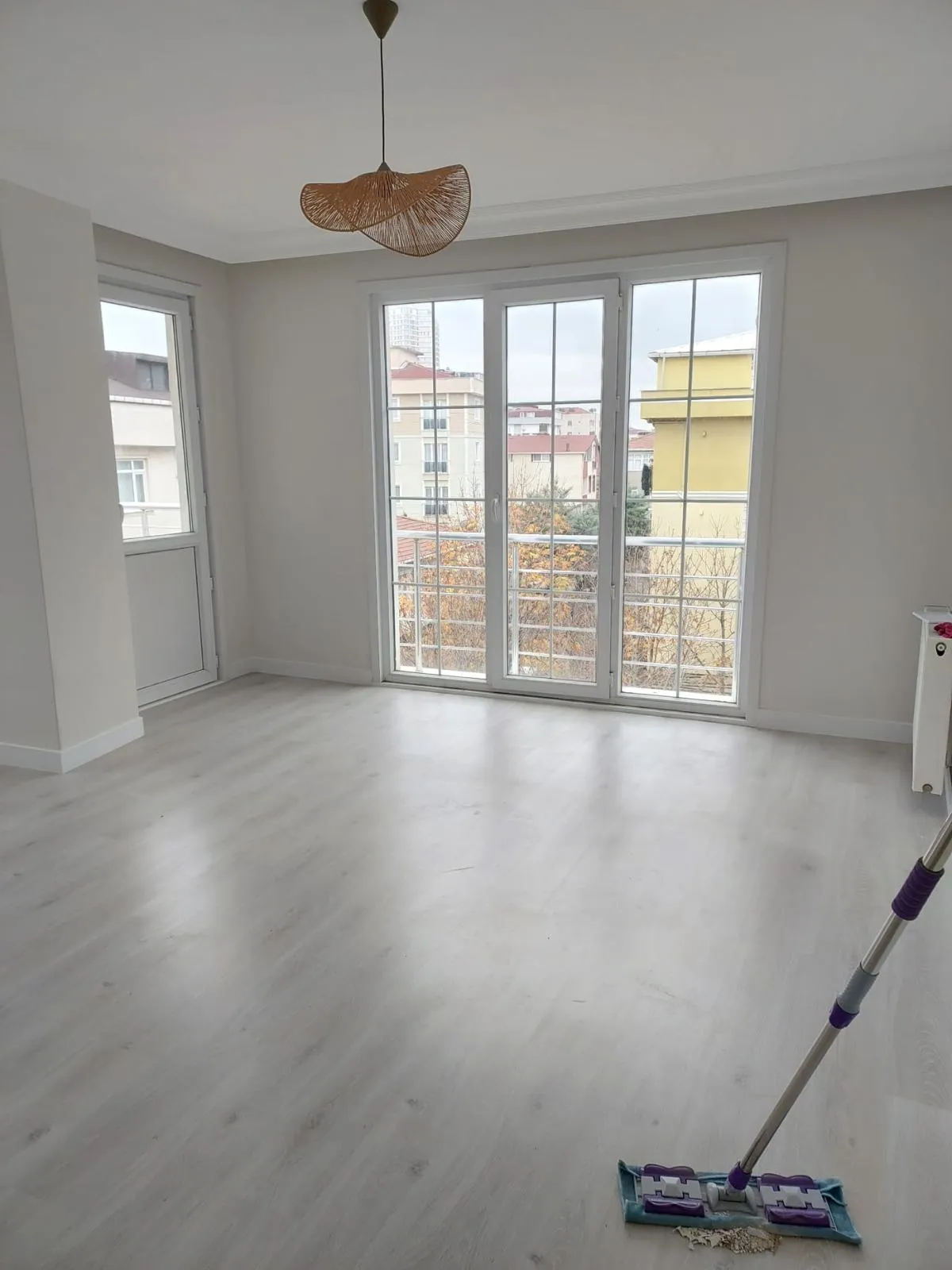 Salon, geniş balkon kapısı ve bol gün ışığı, açık renk laminat zemin
